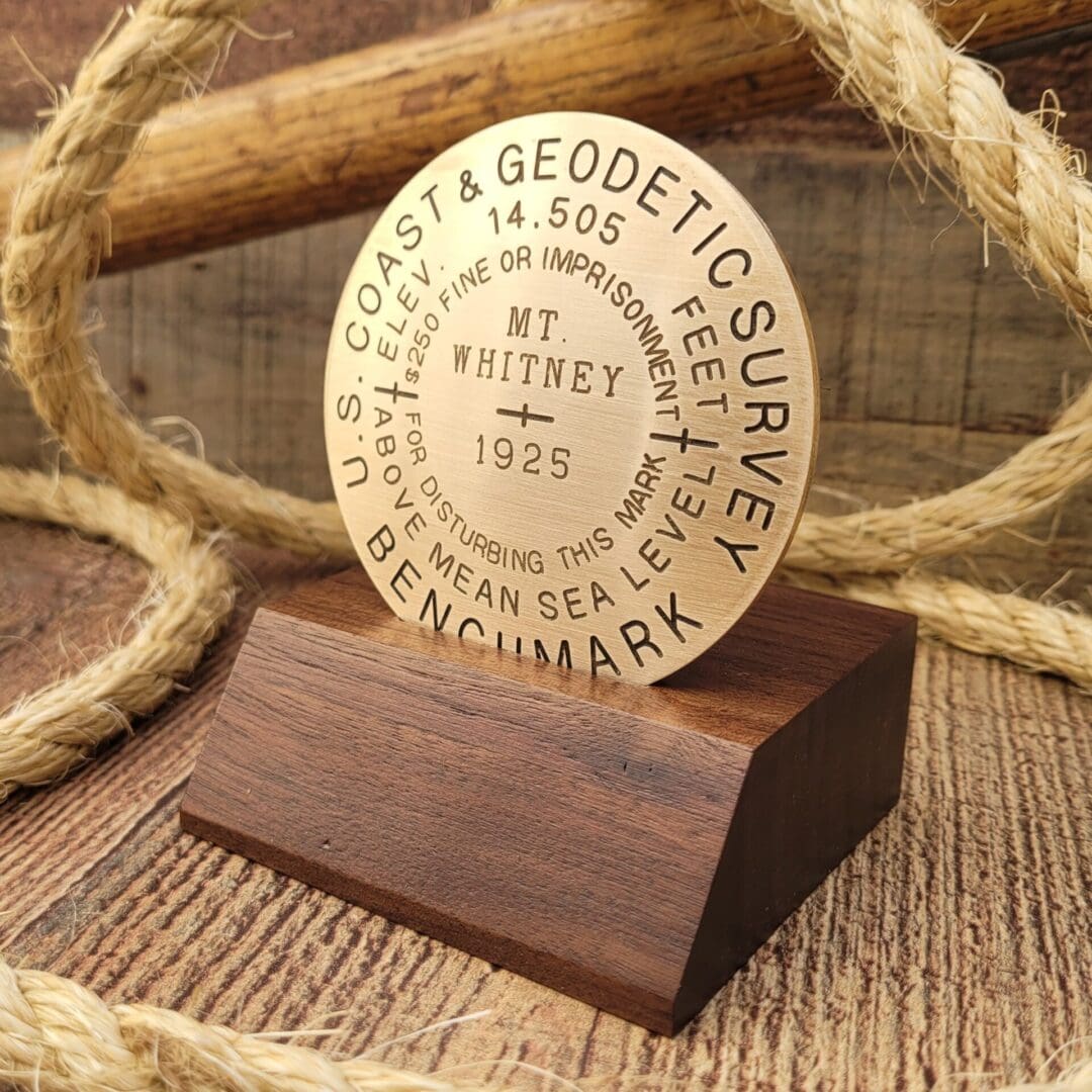 A wooden plaque with a gold disc on it.