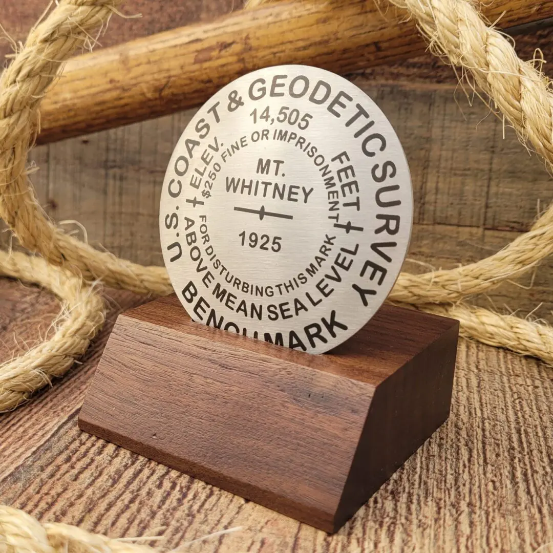 A wooden plaque with a rope and a compass on it.